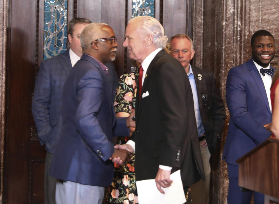 Republican South Carolina Gov. Henry McMaster, right, shakes hands with Rep. Terry Alexander, D-Florence, right, before the ceremonial signing of an early voting bill on Wednesday, May 18, 2022, in Columbia, S.C. (AP Photo/Jeffrey Collins)