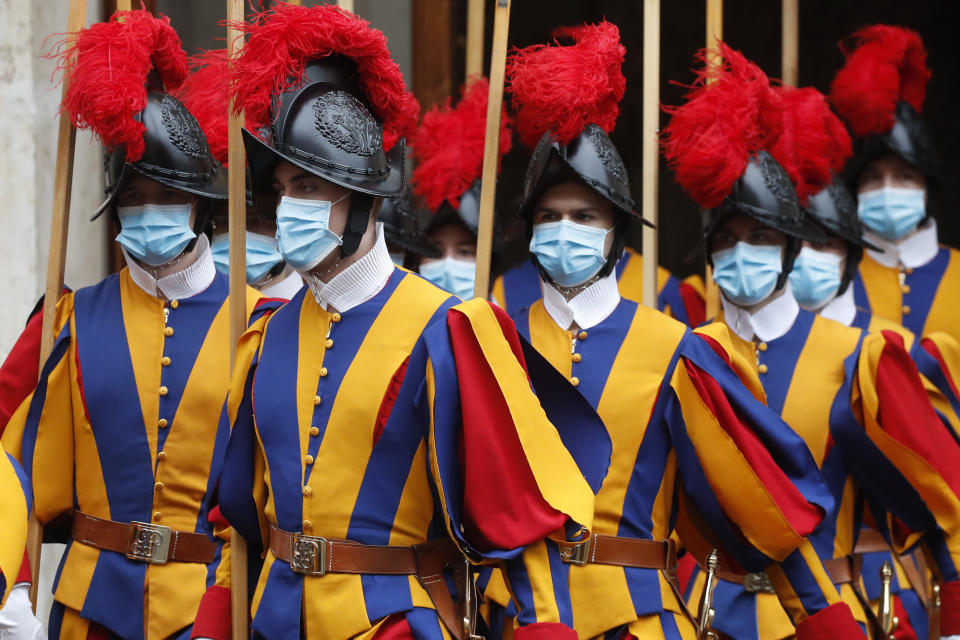 Vatican Swiss Guards, wearing masks to curb the spread of COVID-19, leave the St. Damaso courtyard after Spain's Prime Minister Pedro Sanchez meeting with Pope Francis, at the Vatican, Saturday, Oct. 24, 2020. (AP Photo/Alessandra Tarantino)