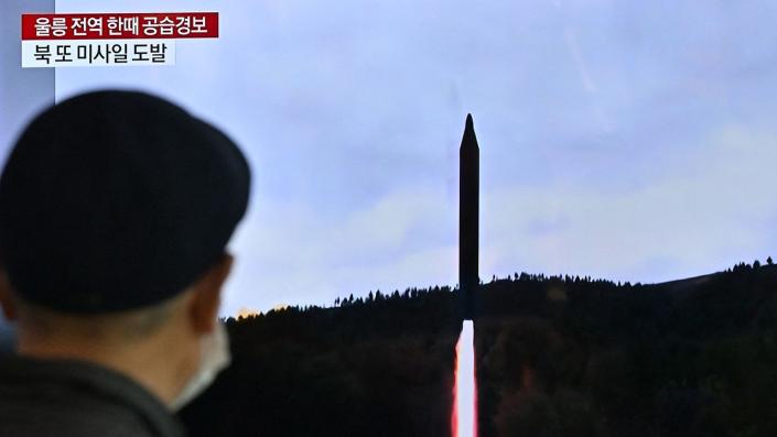 A man watching a North Korean missile launch on a tv