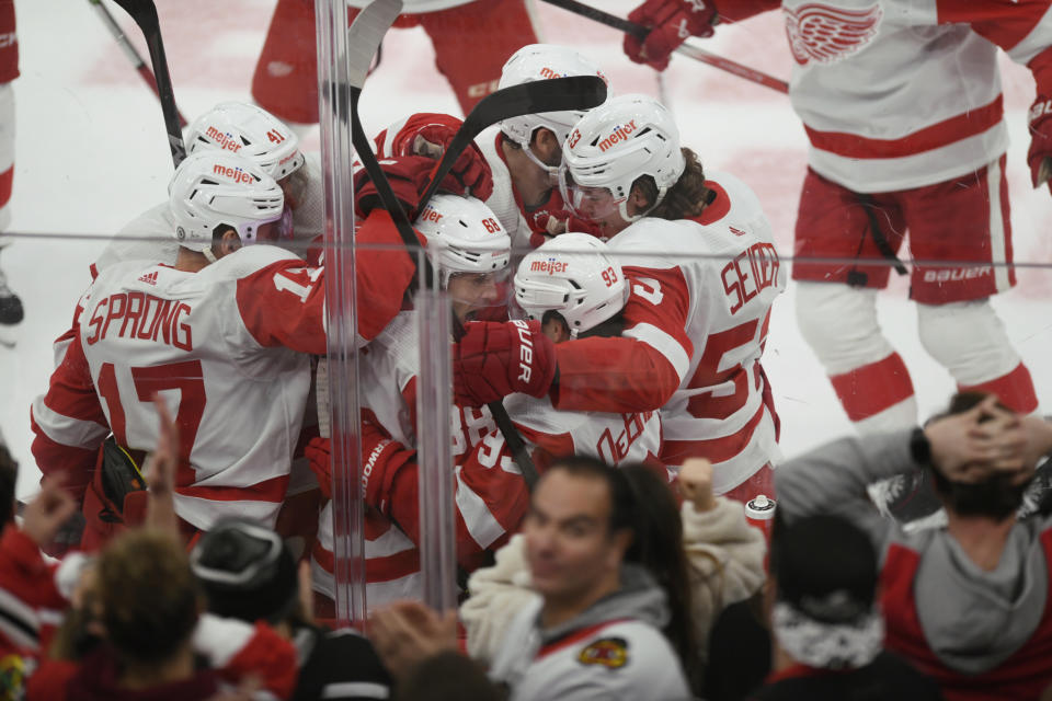 Detroit Red Wings' Patrick Kane (88) celebrates with teammates after scoring the winning goal against Chicago Blackhawks goalie Petr Mrazek (34) to win 3-2 in overtime in an NHL hockey game, Sunday, Feb. 25, 2024, in Chicago. (AP Photo/Paul Beaty)