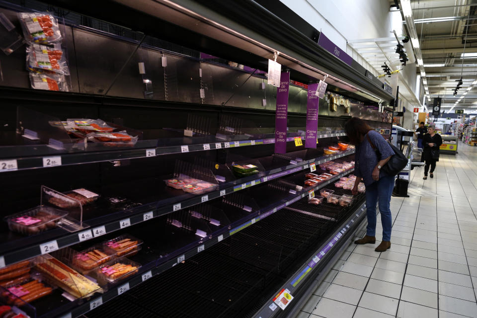 Empty shelves in a supermarket in Madrid, Spain, Tuesday, March 10, 2020. People have emptied shelves of food and supplies in supermarkets in Madrid after Spain's health minister on Monday announced a sharp spike in coronavirus cases in and around the national capital, and said all schools in the region, including kindergartens and universities, will close for two weeks from Wednesday. (AP Photo/Manu Fernandez)