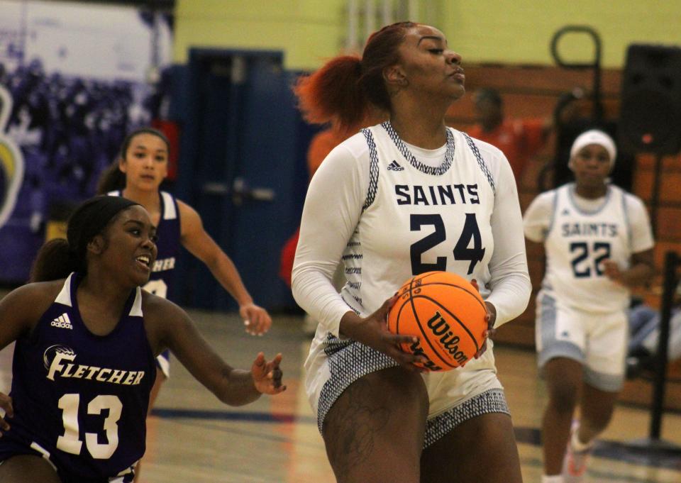 Sandalwood center Jada Jones (24) grabs a loose ball as Fletcher guard Lavin Savage (13) defends during a Gateway Conference high school girls basketball tournament game on January 9, 2023. [Clayton Freeman/Florida Times-Union]