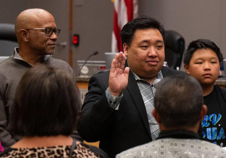 Interim District 2 Sacramento City Councilman Shoun Thao, joined by family members and former Councilman Allen Warren, is sworn-in by City Clerk Mindy Cuppy on Tuesday, April 2, 2024. Thao worked as a city staffer for Warren.