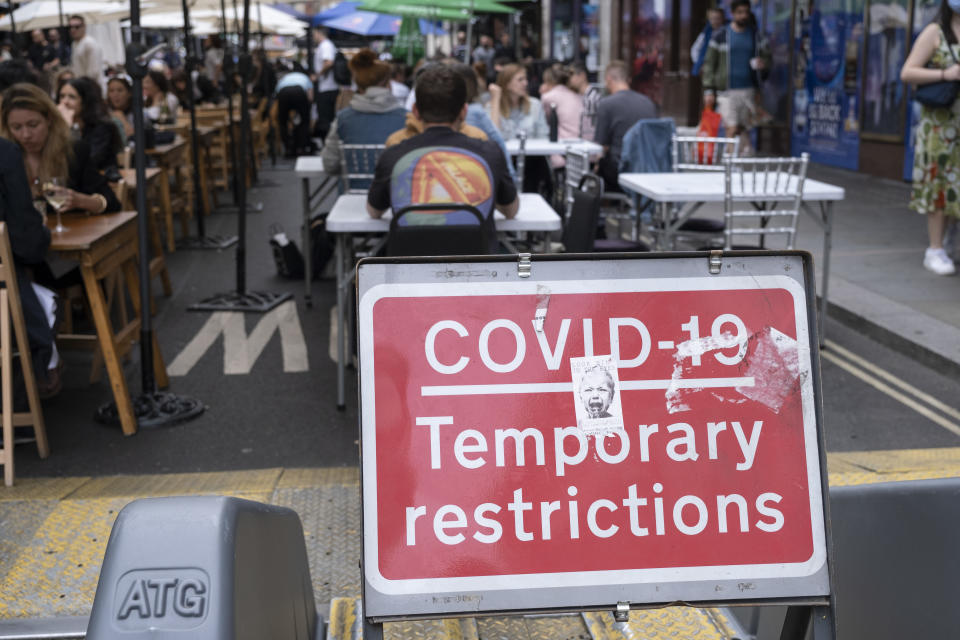 People eat and socialize at outdoor tables on Old Compton Street in Soho in London. (Mike Kemp/In Pictures via Getty Images)