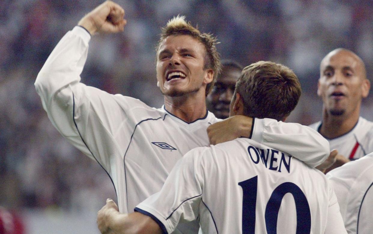 English captain and midfielder David Beckham (L) congratulates his teammate Michael Owen after he scored their team's second goal during the second round match Denmark/England in the 2002 FIFA World Cup in Korea and Japan