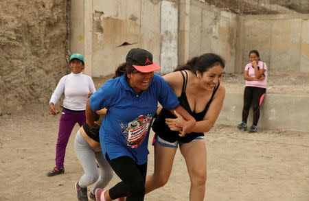Martha Injusta (L) and Leydi Condor, residents of Nueva Union shantytown, play a volleyball match at a makeshift soccer field in Villa Maria del Triunfo district of Lima, Peru, April 25, 2018. REUTERS/Mariana Bazo
