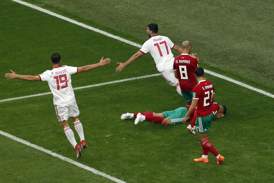 <p>Players of iran celebrate as Morocco’s Aziz Bouhaddouz lies on the pitch after scoring an own goal during the group B match between Morocco and Iran at the 2018 soccer World Cup in the St. Petersburg Stadium in St. Petersburg, Russia, Friday, June 15, 2018. (AP Photo/Darko Vojinovic) </p>