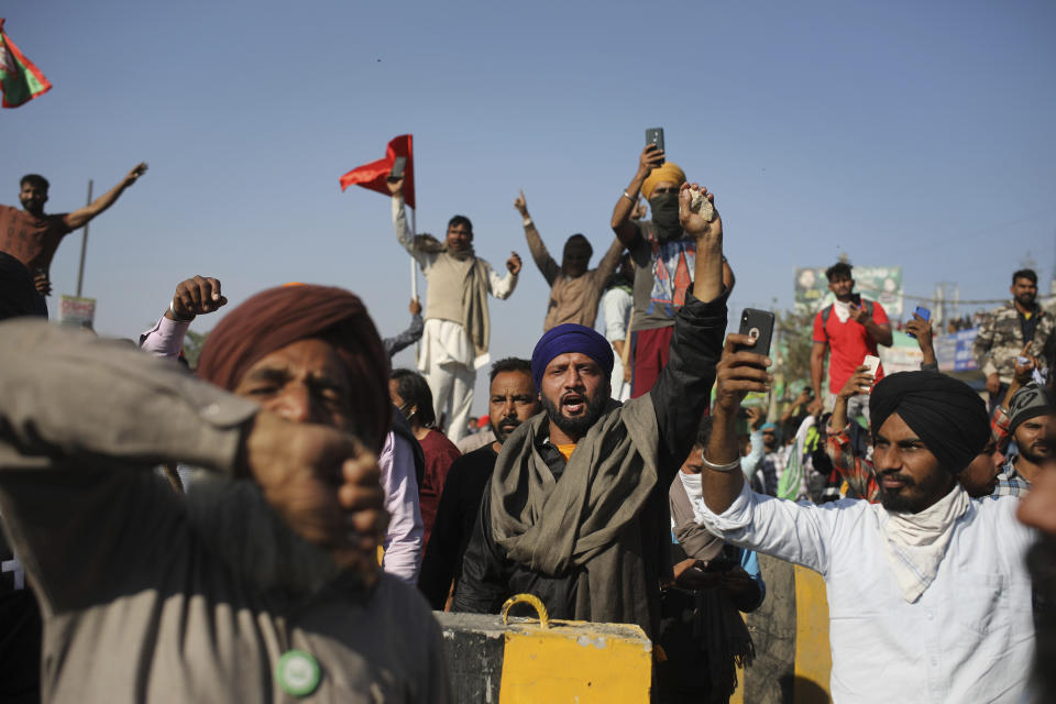 Protesting farmers shout slogans as they attempt to move towards Delhi, at the border between Delhi and Haryana state, Friday, Nov. 27, 2020. Thousands of agitating farmers in India faced tear gas and baton charge from police on Friday after they resumed their march to the capital against new farming laws that they fear will give more power to corporations and reduce their earnings. While trying to march towards New Delhi, the farmers, using their tractors, cleared concrete blockades, walls of shipping containers and horizontally parked trucks after police had set them up as barricades and dug trenches on highways to block roads leading to the capital. (AP Photo/Altaf Qadri)