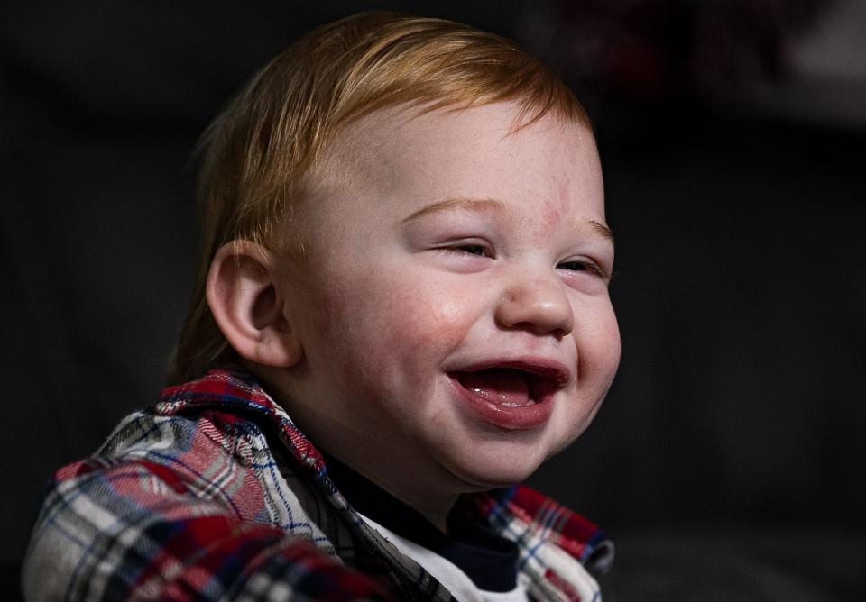 Wesson Keene, 1, has a big smile for his mother during a recent therapy session at his home in Lexington, Ky. Wesson's father died of COVID-19 complications near the time of his premature birth.