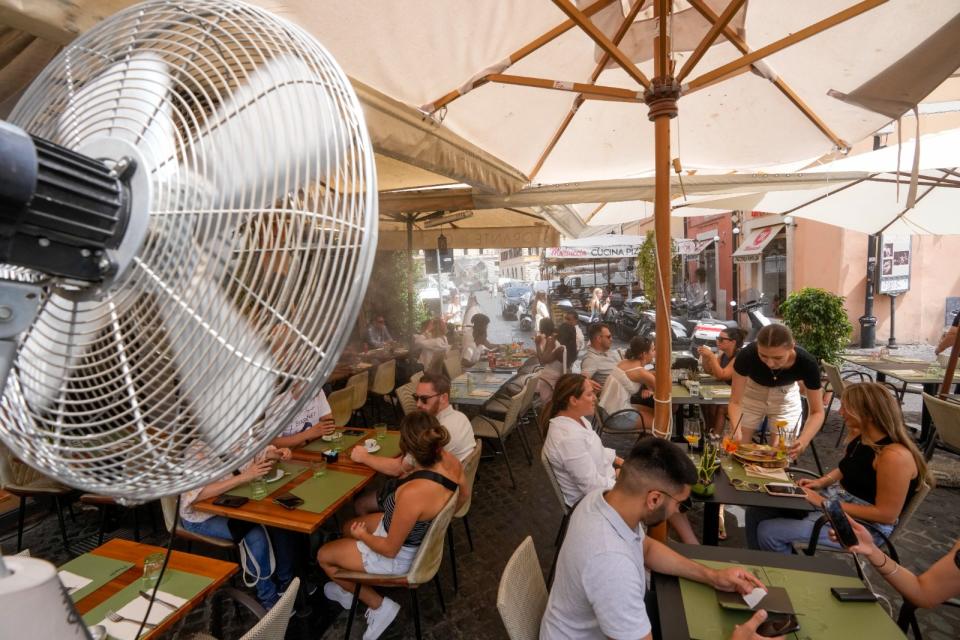 去年7月熱浪中的義大利羅馬，一間餐廳用電風扇幫戶外座位的餐客降溫。美聯社