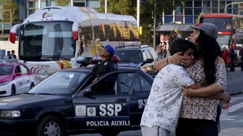 Una mujer abraza a un niño durante un sismo en México