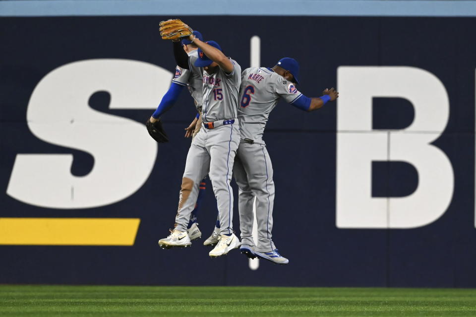 From left to right, New York Mets' Brandon Nimmo, Tyrone Taylor and Starling Marte celebrate after their victory over the Toronto Blue Jays in baseball game action in Toronto, Monday, Sept. 9, 2024. (Jon Blacker/The Canadian Press via AP)