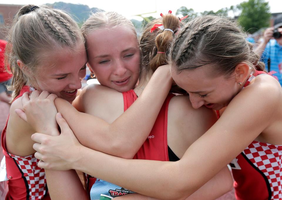 Lourdes Academy’s Dasha Averkamp, Erin Moore, Molly Moore and Mackenzie Stelter embrace after winning the 3,200 relay in Division 3 at the WIAA state track and field championships Saturday in La Crosse.