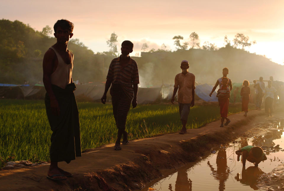 Rohingya refugees walk on a muddy path at Thaingkhali makeshift refugee camp in Cox's Bazar, Bangladesh, on Sept. 14, 2017.