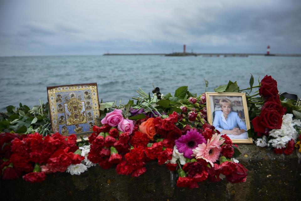 An icon and a portrait of Yelizaveta Glinka are placed among flowers at a pier in Sochi, Russia, in Sochi, Russia, Wednesday, Dec. 28, 2016. All 84 passengers and eight crew members on the Russian military's Tu-154 plane are believed to have died Sunday morning when it crashed two minutes after taking off from the southern Russian city of Sochi. Glinka, a Russian doctor widely known for her charity efforts, was among those on board. (AP Photo/Viktor Klyushin)