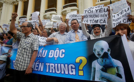 Demonstrators, holding signs to protest against Taiwanese enterprise Formosa Plastic and environmental-friendly messages, say they are demanding cleaner waters in the central regions after mass fish deaths in recent weeks, in Hanoi, Vietnam May 1, 2016. REUTERS/Kham