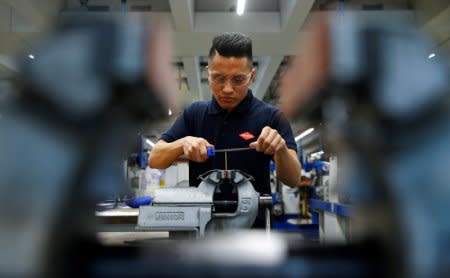 FILE PHOTO: Ahmad Hosseini, 18-year-old trainee and former refugee from Afghanistan is pictured through a plain vice at the training workshop of Knipex, a 130 year-old family-owned pliers and tools maker company in Wuppertal, western Germany, October 25, 2016. Picture taken October 25, 2016.   REUTERS/Wolfgang Rattay/File Photo