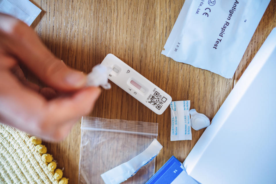 Testing can lead to a change of behaviour and prevent people from spreading COVID-19 to others. (Getty) A woman squeezing the sample liquid on a test strip while carrying out a Covid-19 rapid self test at home.