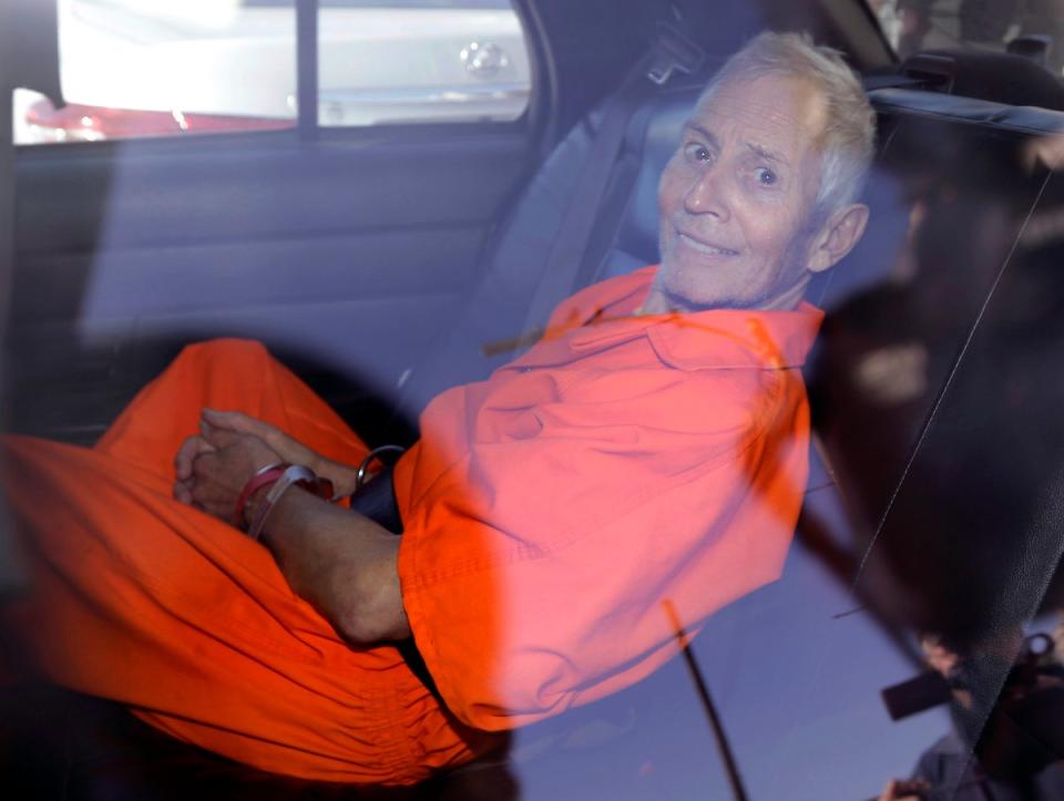 Robert Durst vestido con el uniforme de la prisión sonríe después de haber sido arrestado por el asesinato de Susan Berman en 2015 (AP)