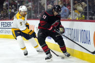 Nashville Predators left wing Filip Forsberg (9) and Carolina Hurricanes left wing Warren Foegele (13) chase the puck during the second period in Game 1 of an NHL hockey Stanley Cup first-round playoff series in Raleigh, N.C., Monday, May 17, 2021. (AP Photo/Gerry Broome)