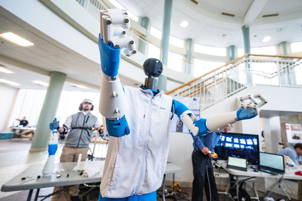 Wearing a tracking vest, May graduate Luke Maness of Lexington, Tenn., guides the robot, “Candice Be Human,” during the annual Middle Tennessee State University Mech-Tech, an expo for Engineering Technology and Mechatronics Engineering students held during study day.