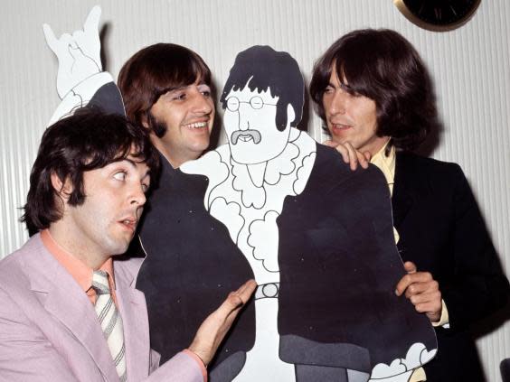 Paul McCartney, Ringo Starr and George Harrison pose with a cardboard John Lennon cut out in his absence in 1968 (Bill Zygmant/Shutterstock)