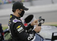 Jimmie Johnson uses his cell phone on pit road before the NASCAR Cup Series auto race at Daytona International Speedway, Saturday, Aug. 29, 2020, in Daytona Beach, Fla. Johnson was involved in a late-race crash. (AP Photo/Terry Renna)