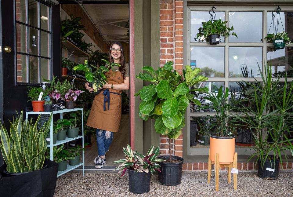 Tina Turman, owner of Planted cctx, holds a plant in the doorway of her store on April 22, 2022, in Corpus Christi, Texas.