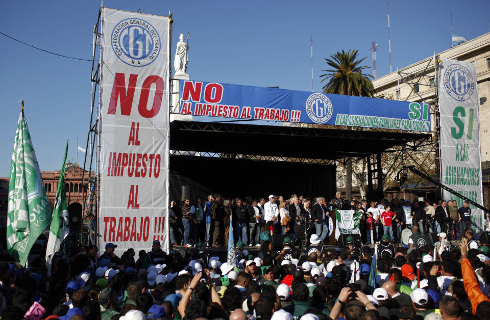 People gather to listen to union leader Hugo Moyano speak during a protest at Plaza de Mayo in Buenos Aires, Argentina, Wednesday, June 27, 2012. The strike and demonstration called by Moyano demands steps that would effectively reduce taxes on low-income people, among other measures. The signs read in Spanish "No to the income tax." (AP Photo/Natacha Pisarenko)