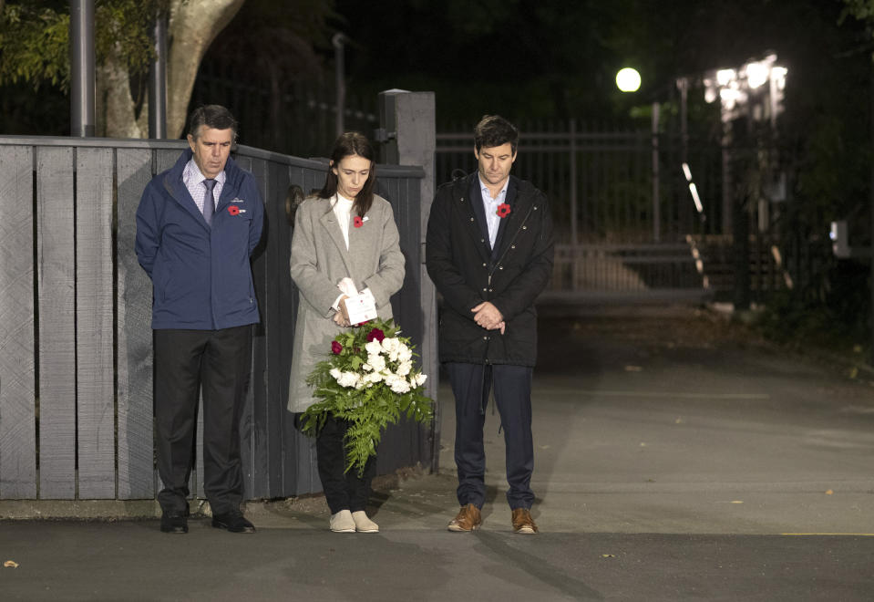 New Zealand Prime Minister Jacinda Ardern stands at dawn on the driveway of Premier House with her father Ross Ardern, left and partner Clarke Gayford to commemorate Anzac Day in Wellington, New Zealand, Saturday, April 25, 2020. Many New Zealanders participated in the "Stand At Dawn" initiative to commemorate Anzac Day after the traditional services were canceled due to COVID-19. (Ross Giblin/Dominion Post, Pool photo via AP)