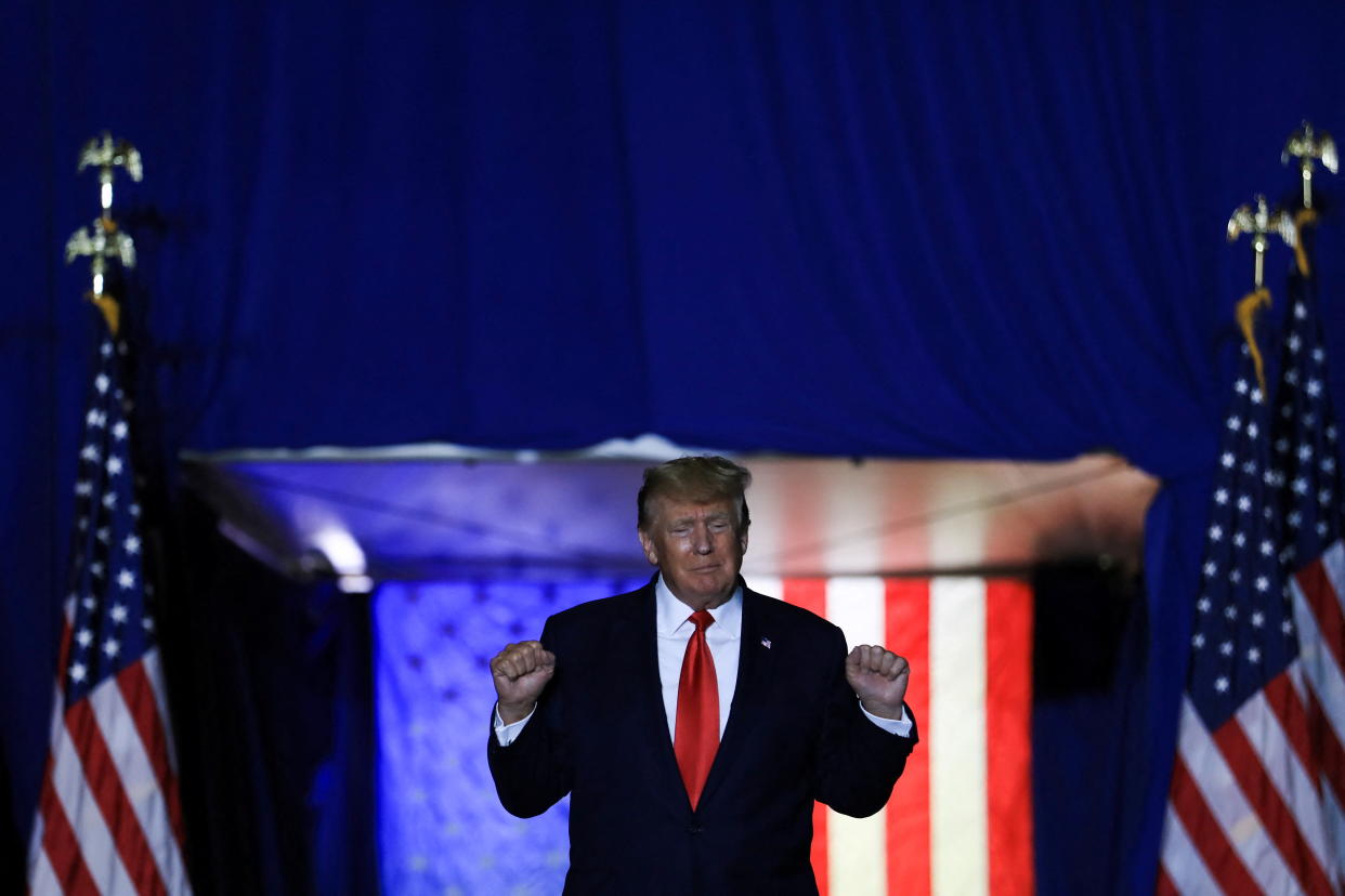 Former U.S. President Donald Trump shakes his fists as he makes his entrance into a rally held in Washington Township, Michigan, U.S. April 2, 2022. REUTERS/Emily Elconin