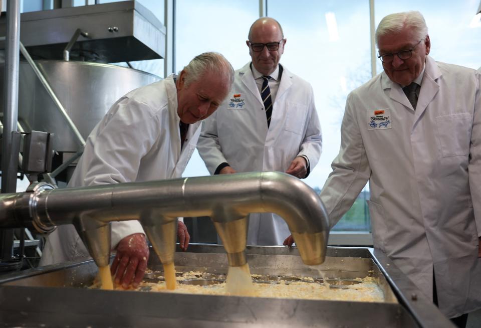 Charles III. (l.) beim Käsemachen im Ökodorf, mit Bundespräsident Frank-Walter Steinmeier (r.) und Brandenburgs Ministerpräsident Dietmar Woidke. (Bild: Reuters)