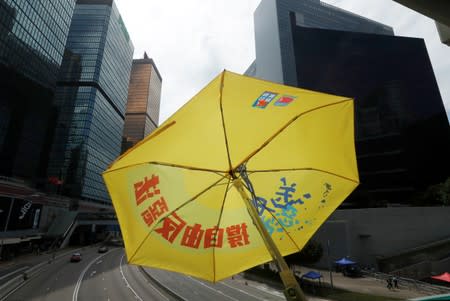 lA yellow umbrella is displayed in front of the Legislative Council building, as people gather to wait for a government announcement regarding the proposed extradition bill, in Hong Kong
