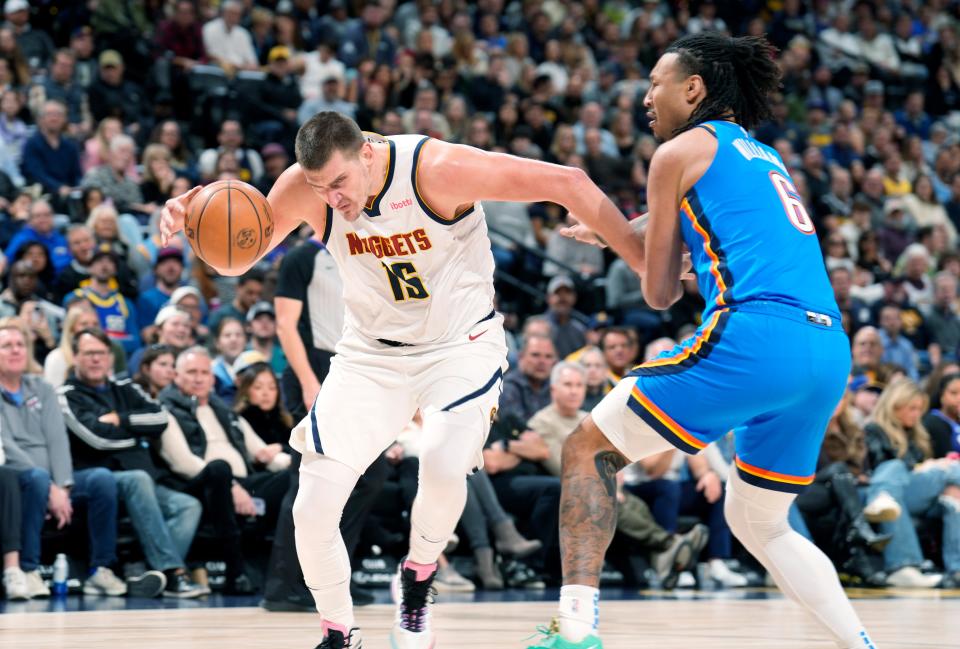 Denver Nuggets center Nikola Jokic, left, drives to the basket past Oklahoma City Thunder forward Jaylin Williams, right, in the first half of an NBA basketball game Friday, Dec. 29, 2023, in Denver. (AP Photo/David Zalubowski)