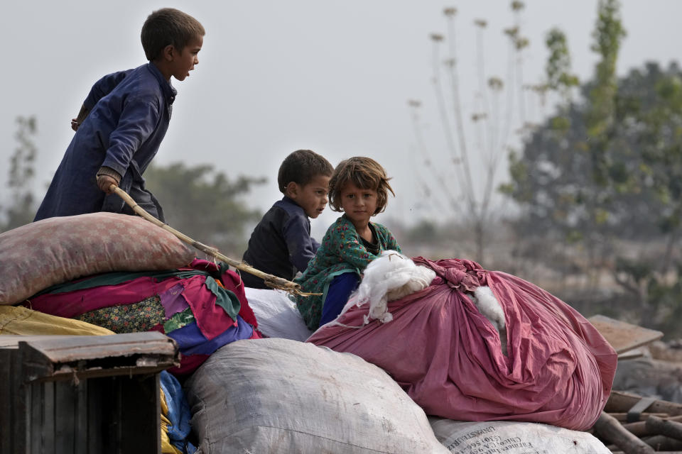 Afghan children sit over their family's belongings retrieved from their damaged mud homes demolished by authorities during a crackdown against an illegal settlement and immigrants, on the outskirts of Islamabad, Pakistan, Wednesday, Nov. 1, 2023. (AP Photo/Anjum Naveed)