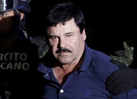 Recaptured drug lord Joaquin "El Chapo" Guzman is escorted by soldiers at the hangar belonging to the office of the Attorney General in Mexico City, Mexico January 8, 2016. REUTERS/Henry Romero