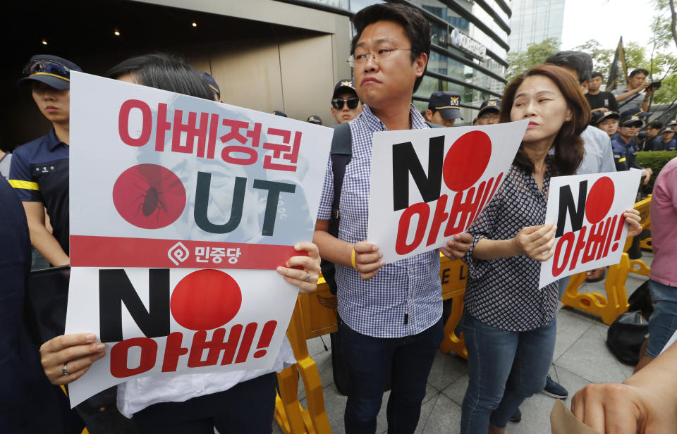 South Korean protesters hold cards during a rally against Japan in front of a building which houses Japanese embassy in Seoul, South Korea, Friday, Aug. 2, 2019. Japan's Cabinet on Friday approved the removal of South Korea from a "whitelist" of countries with preferential trade status, a move sure to fuel antagonism already at a boiling point over recent export controls and the issue of compensation for wartime Korean laborers. The signs read " Japanese Prime Minister Shinzo Abe." (AP Photo/Ahn Young-joon)