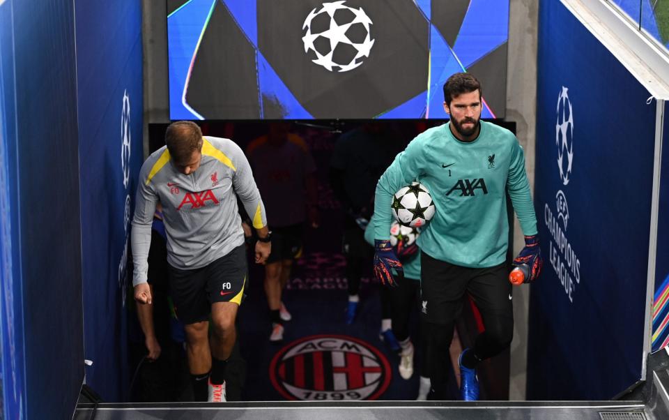 Alisson climbs up the stairs at San Siro