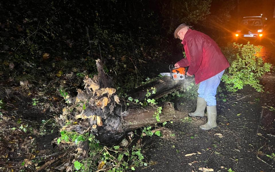 One man tackles a fallen tree on the A272 in Ansty, West Sussex