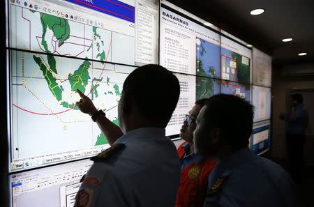 Military and rescue authorities monitor progress in the search for AirAsia Flight QZ8501 in the Mission Control Center inside the National Search and Rescue Agency in Jakarta December 29, 2014. REUTERS/Darren Whiteside