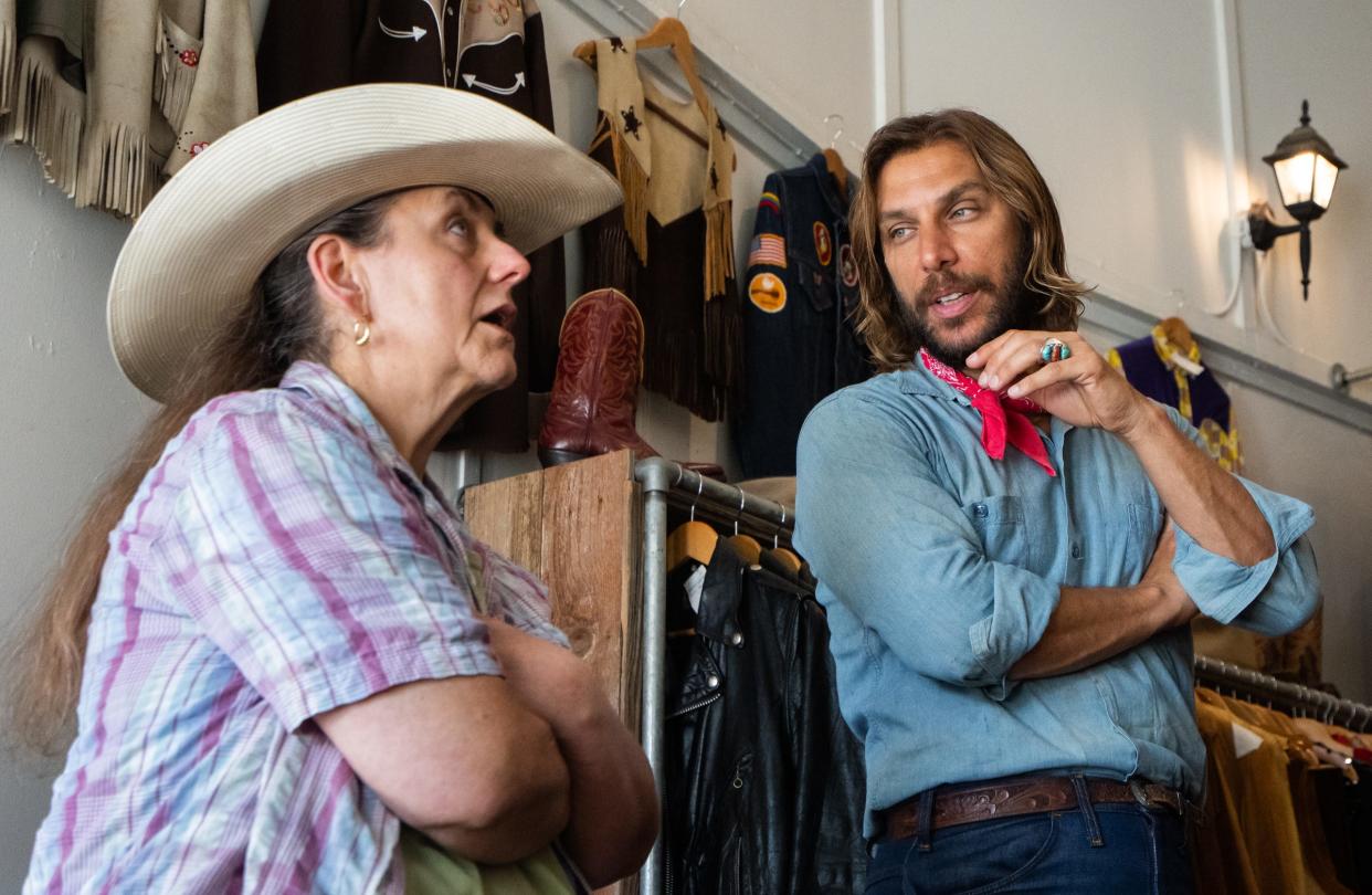 Full Circle Vintage Owner and boot-finder Joey Medina, right, talk with Jan Bessette about what she is looking for in new pair of boots at his Lockhart store, June 30, 2023. 