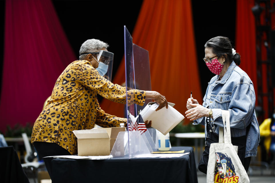 A voter, right, checks in with an election worker before casting her ballot in the Pennsylvania primary in Philadelphia, Tuesday, June 2, 2020. (AP Photo/Matt Rourke)