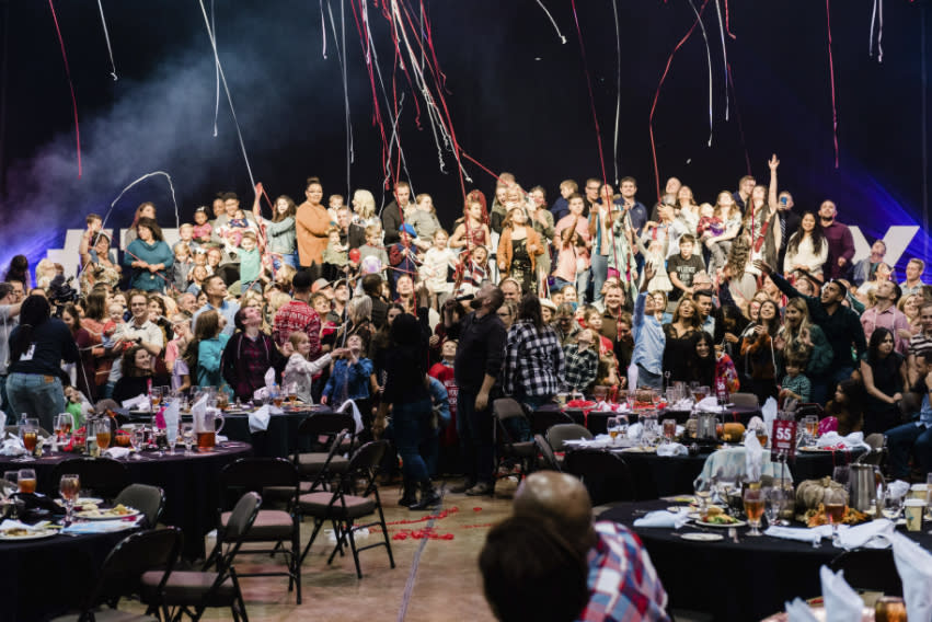 In this Nov. 24, 2019 photo, Bree Carroll helped Every Warrior Network stage a Thanksgiving feast for 1000 airmen and their families at a convention center in Shreveport, La. This year, with COVID-19 making large gatherings impossible, Carroll is organizing families at Minot Air Force base where she lives to each welcome just a few single airmen into their homes for a homemade Thanksgiving meal. (Ro Simantel Photography/Bree Carroll/B. Carroll Events via AP)
