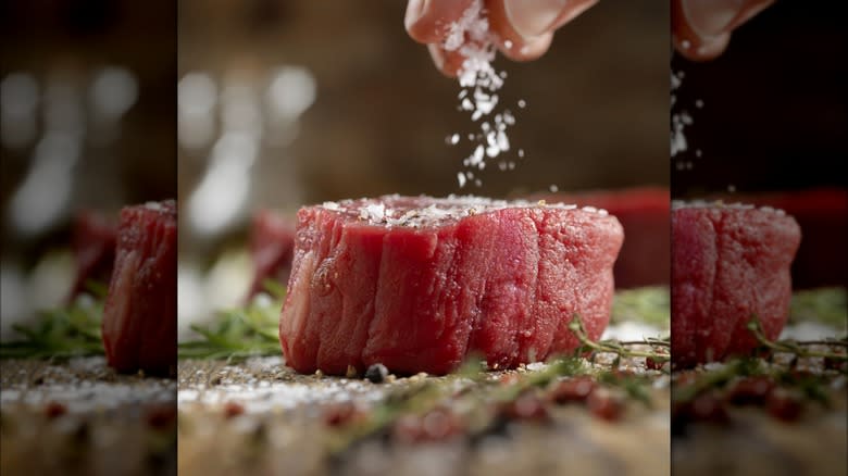 sprinkling salt over raw steak