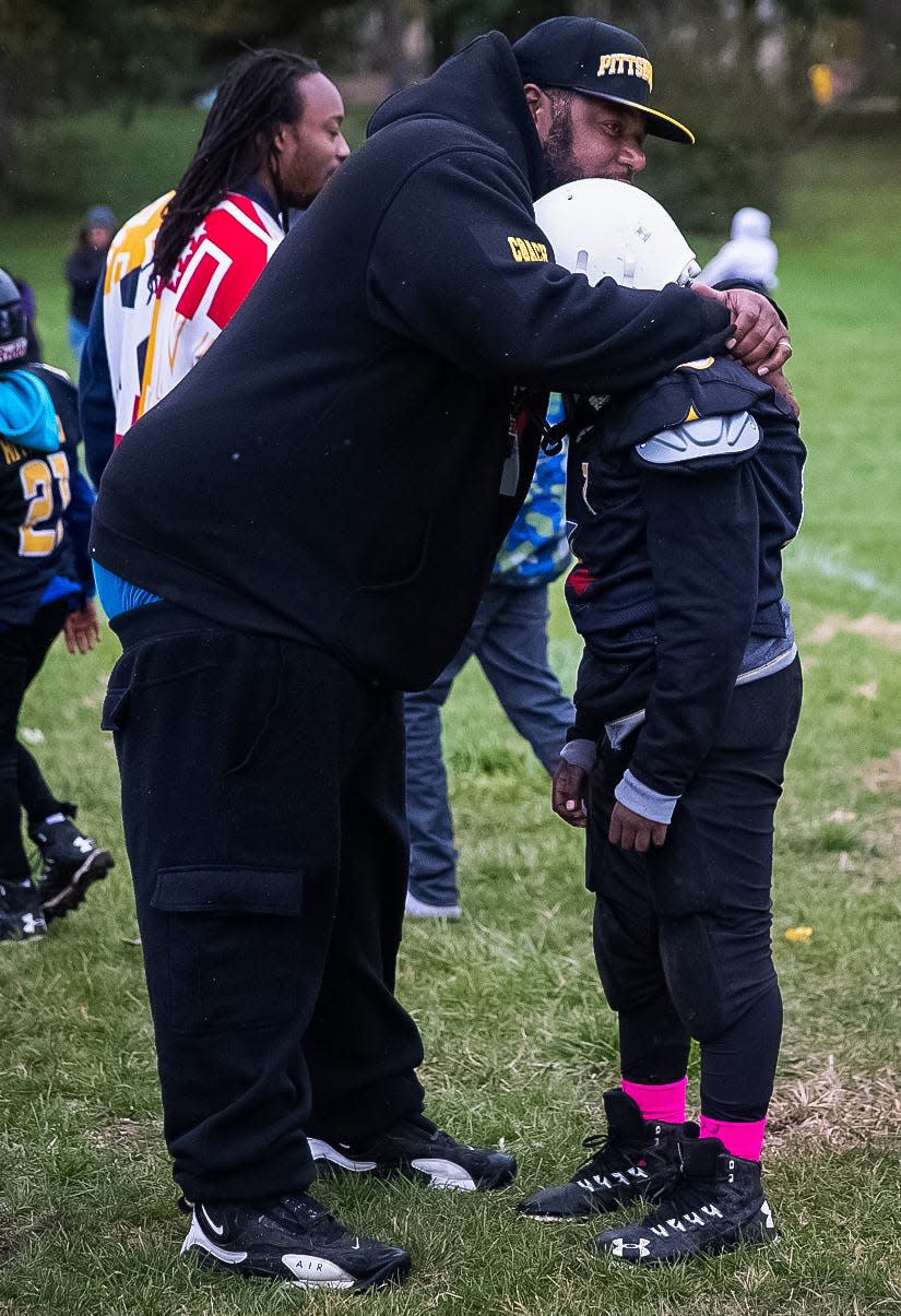 Coach Donnell Hamilton comforts an Indy Steelers player after an 8u team loss at Frederick Douglass Park. "I didn't know when I was in college that I would be a coach," he said. "I think I'm a very passionate coach, I want to teach them everything I know. That's what drives me." 