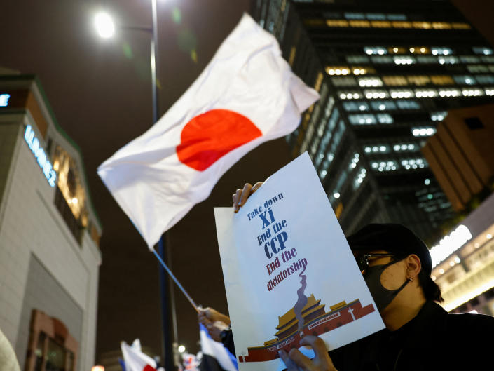 A demonstrator in Tokyo holds a placard during a solidarity protest against China&#39;s COVID-19 lockdowns.