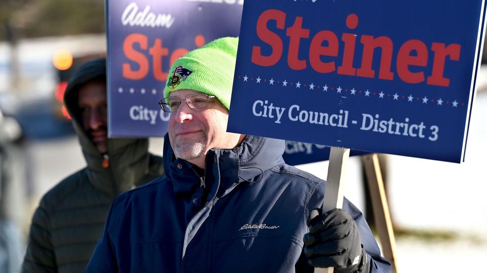 Incumbent Framingham District 3 city councilor Adam Steiner and supporters hold signs in the bitter cold outside the Brophy Elementary School during a special election to determine the winner of the council seat, Jan. 11, 2021.  A recount after  the Nov. 2 municipal election resulted in a tie between Steiner and challenger Mary Kate Feeney and a "failure to elect".  A Middlesex Superior Court judge ruled that a special election was the fairest way to determine the outcome.