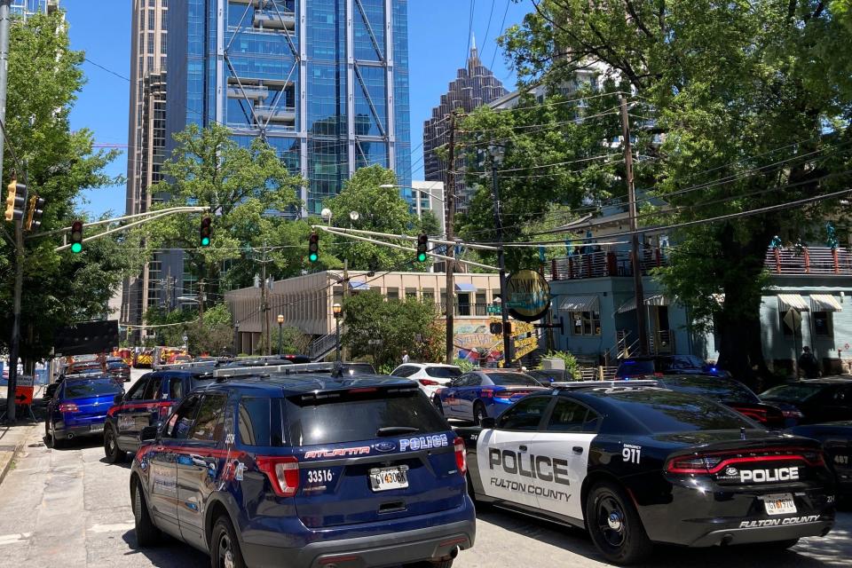 Emergency vehicles arrive on West Peachtree in Atlanta on Wednesday, May 3, 2023.  Police say are investigating an “active shooter situation” in a building in Atlanta's Midtown neighborhood and that multiple people had been injured.