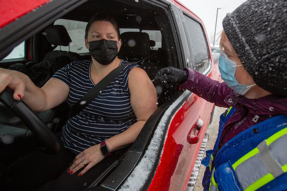 Dr. Elaine Ma administers a vaccine during a drive-through COVID-19 vaccine clinic at St. Lawrence College in Kingston, Ontario, Sunday Jan.  2, 2022.