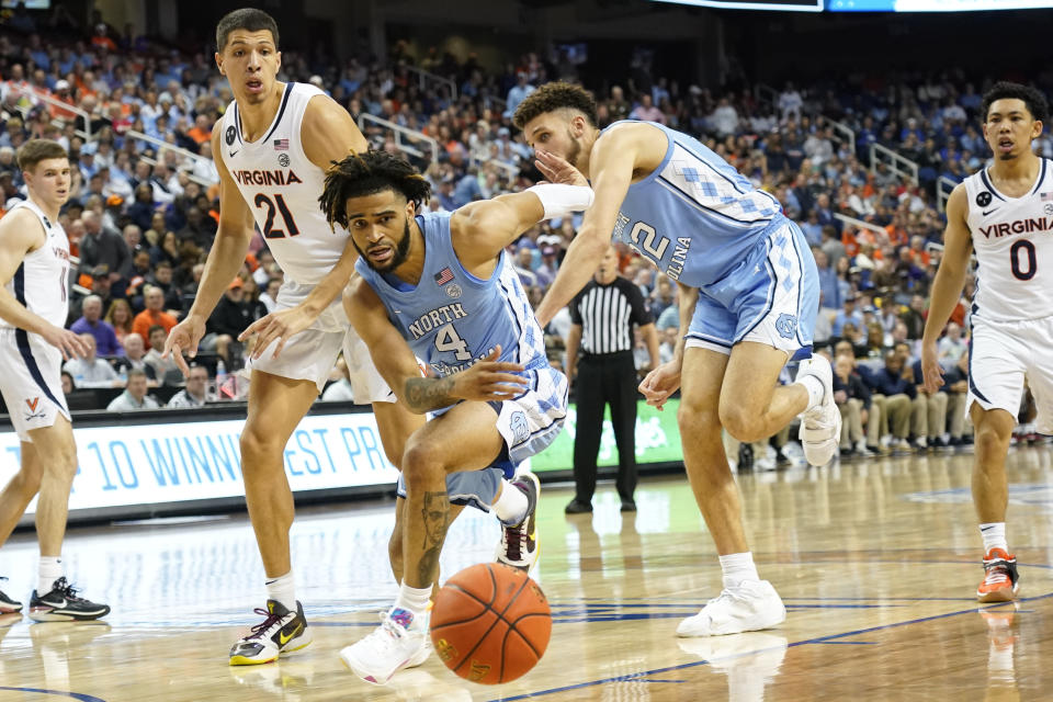 North Carolina guard R.J. Davis (4) and forward Pete Nance (32) chase the ball as Virginia forward Kadin Shedrick (21) watches during the second half of an NCAA college basketball game at the Atlantic Coast Conference Tournament in Greensboro, N.C., Thursday, March 9, 2023. (AP Photo/Chuck Burton)